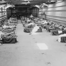 09-7930-2 Once it discharged its wheeled cargo of DUKWs, jeeps and trucks on the invasion beach, an LST tank deck offered ample space for casualties. In the early days of the Pacific campaign there were very few hospital ships in theater, and landing craft and troop transports with negligible medical services offered the only available transportation for the wounded. Original title: First aid to casualties in LST. BuAer 43557; Herman, Battle Station Sick Bay, Naval Institute Press, Photo 13 related to Transformative Furniture: Chairs That Become Beds