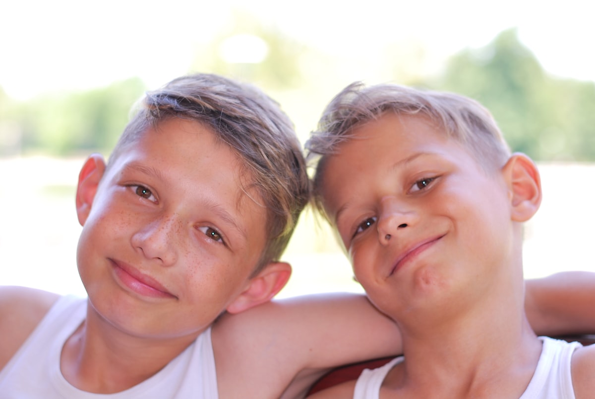 2 boys smiling during daytime related to Building a Simple Twin Bed Frame: A Step-by-Step Guide