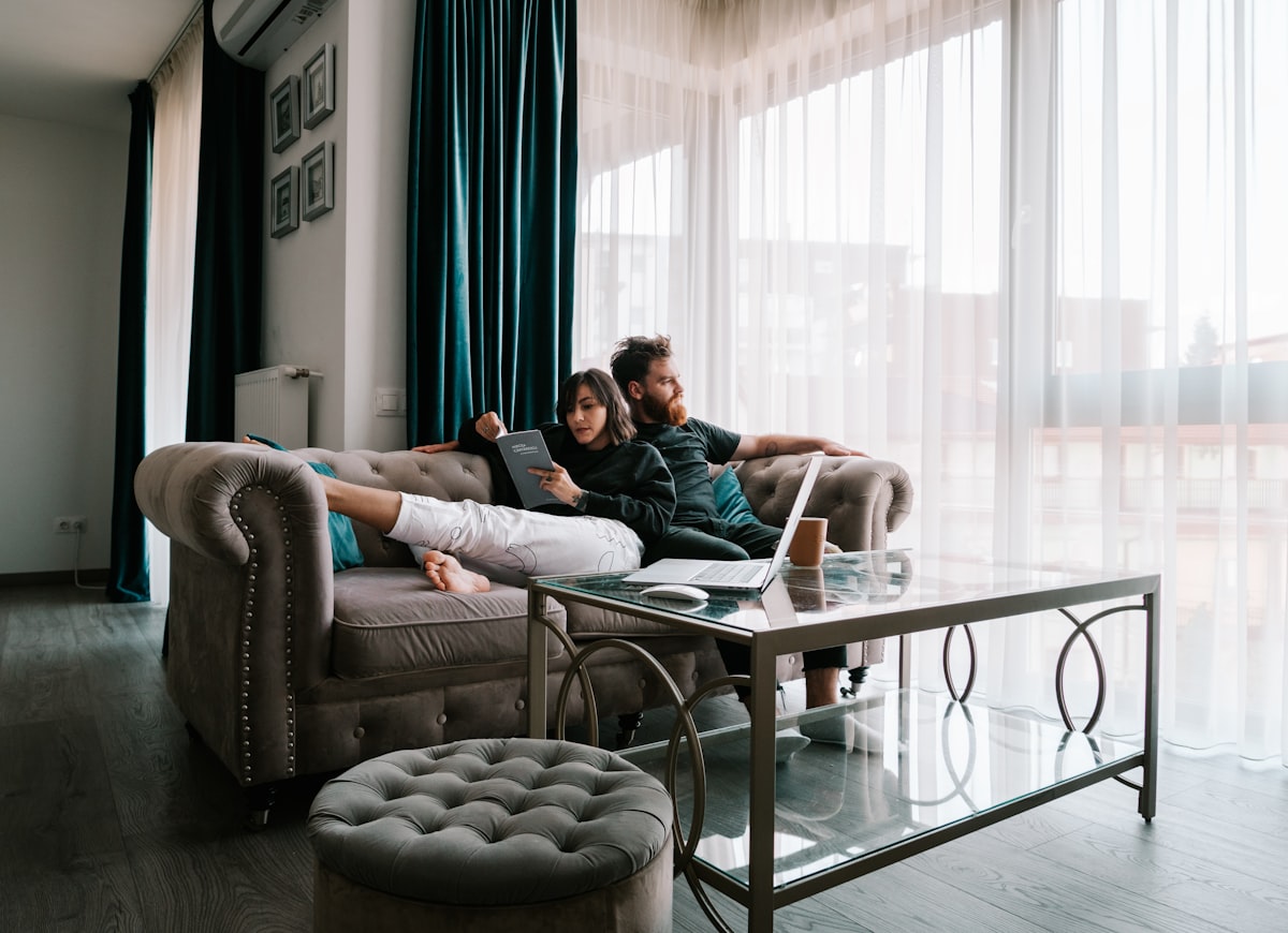 2 women sitting on sofa near window related to Enhancing Your Home Comfort