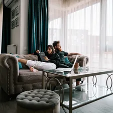 2 women sitting on sofa near window related to Enhancing Your Home Comfort