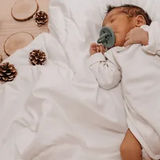 a baby lying on a bed related to 7 Essentials for Creating a Dreamy Gender Neutral Baby Bedding Set