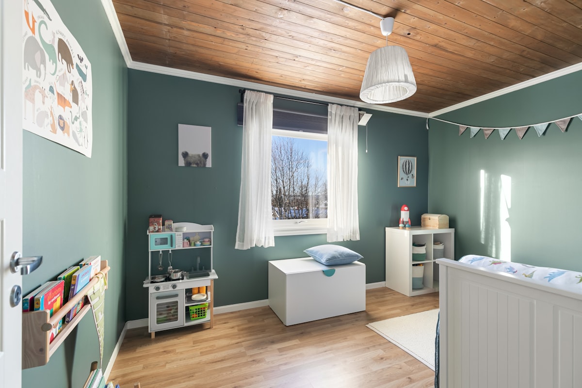 A baby's room with green walls and a wooden ceiling related to Valance for Boys Room