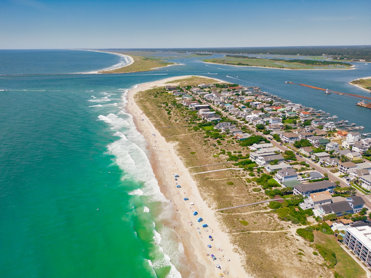 a beach with houses and water related to Wilmington's Cozy Charms: Find Your Perfect Bed and Breakfast
