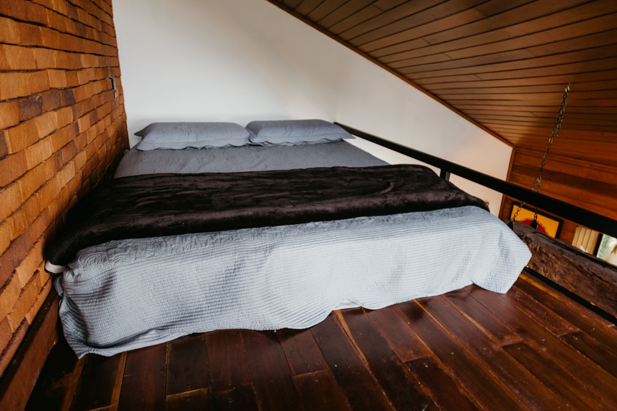 A bed in a room with a wooden floor related to Elevating Sleep and Style: The Twin Loft Bed Revolution