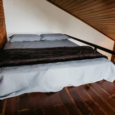 A bed in a room with a wooden floor related to Elevating Sleep and Style: The Twin Loft Bed Revolution