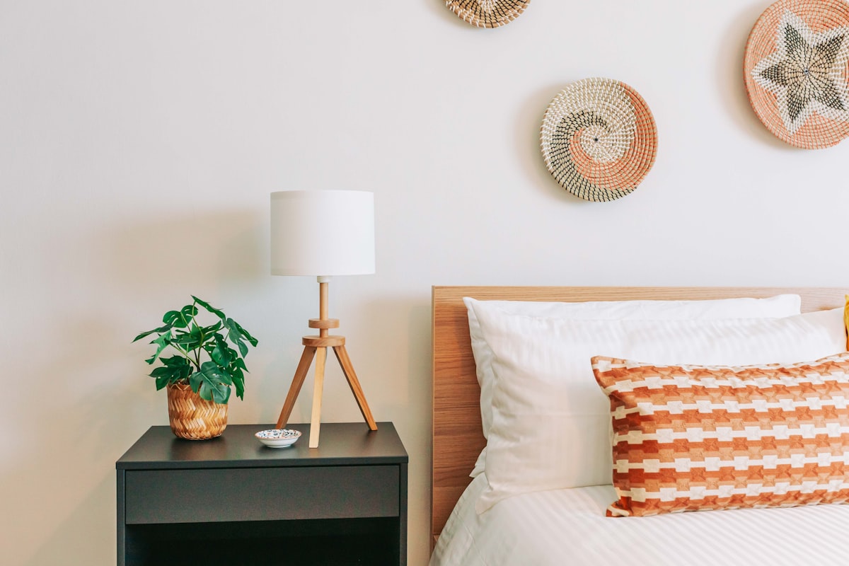 a bed room with a neatly made bed and a night stand related to Revamp Your Bedroom with Pottery Barn's Exciting Bedding Sale