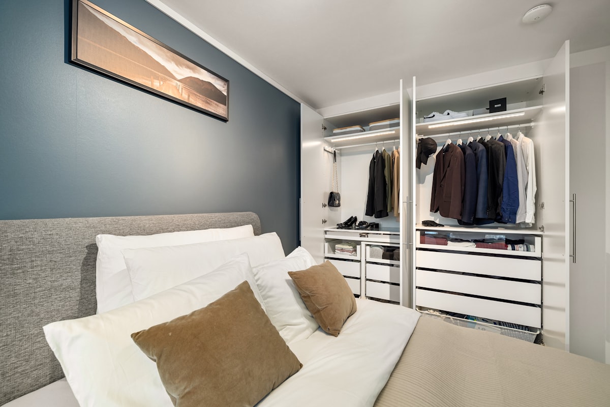 A bed sitting in a bedroom next to a closet related to Maximizing Space: The Benefits of a Closet Bed Frame