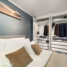 A bed sitting in a bedroom next to a closet related to Maximizing Space: The Benefits of a Closet Bed Frame