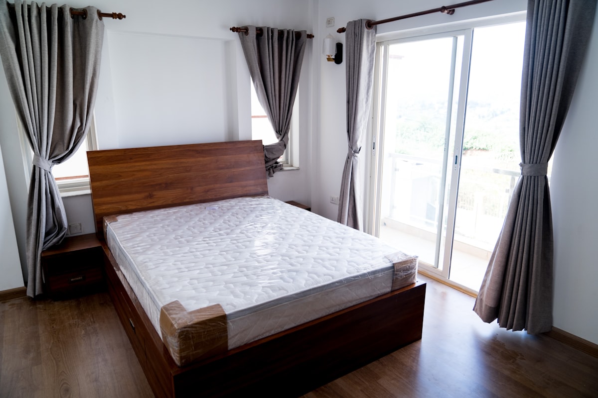 A bed sitting in a bedroom next to a sliding glass door related to Get That Perfect Glow: Top Options for Tanning Beds for Sale