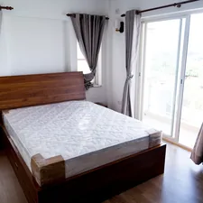 A bed sitting in a bedroom next to a sliding glass door related to Get That Perfect Glow: Top Options for Tanning Beds for Sale