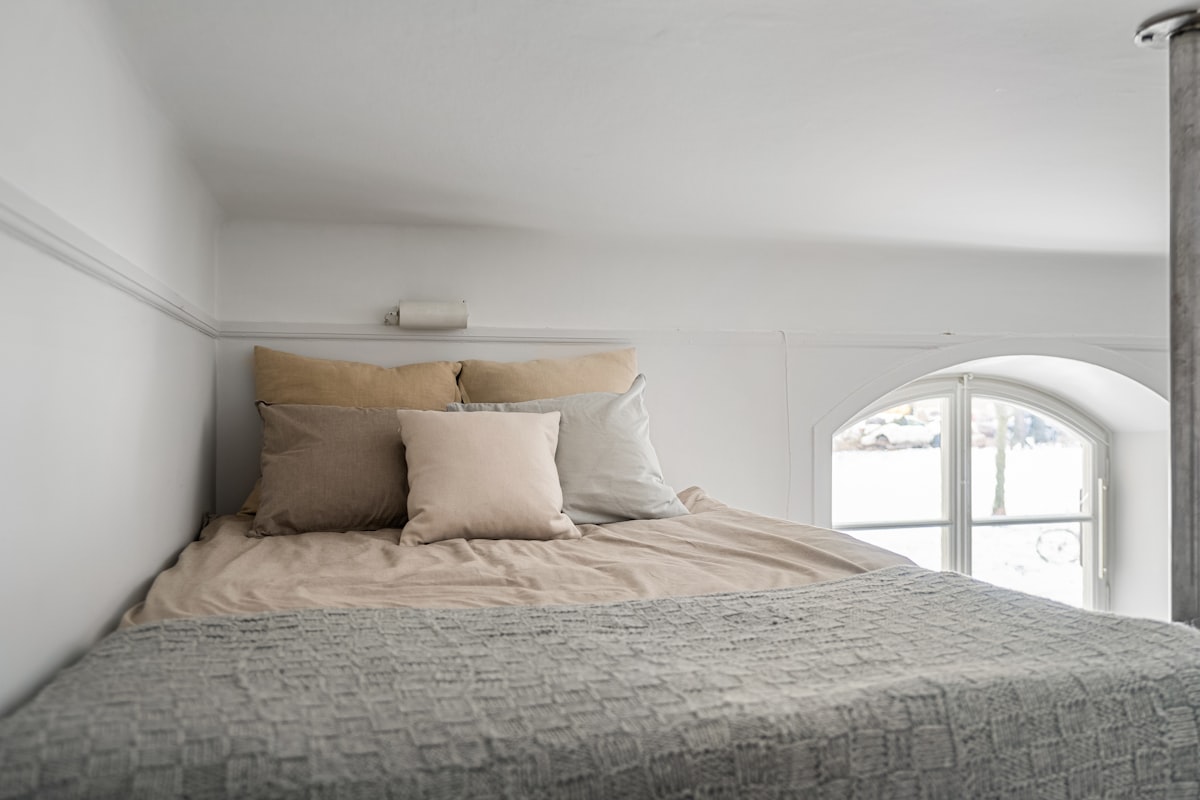 A bed sitting in a bedroom next to a window related to Elevating Sleep and Style: The Twin Loft Bed Revolution