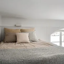 A bed sitting in a bedroom next to a window related to Elevating Sleep and Style: The Twin Loft Bed Revolution