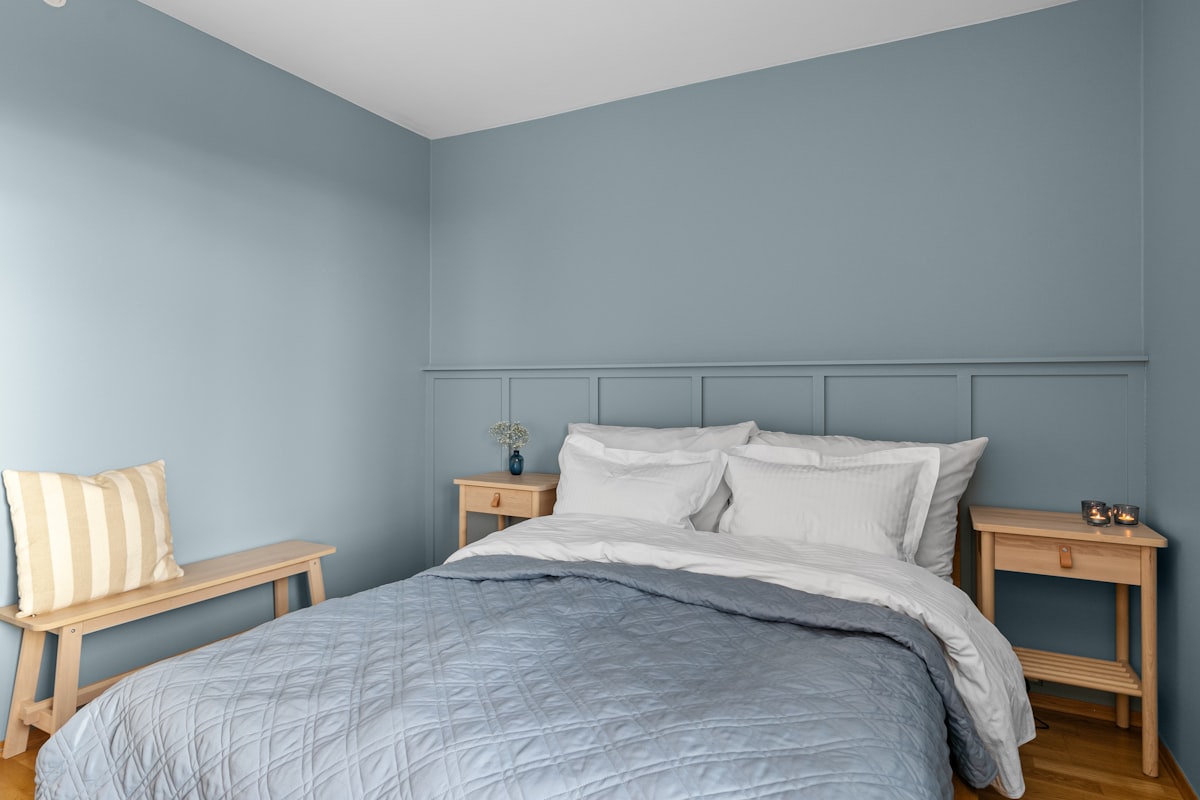 A bed sitting in a bedroom next to a window related to French Blue Bedding: A Touch of Parisian Elegance