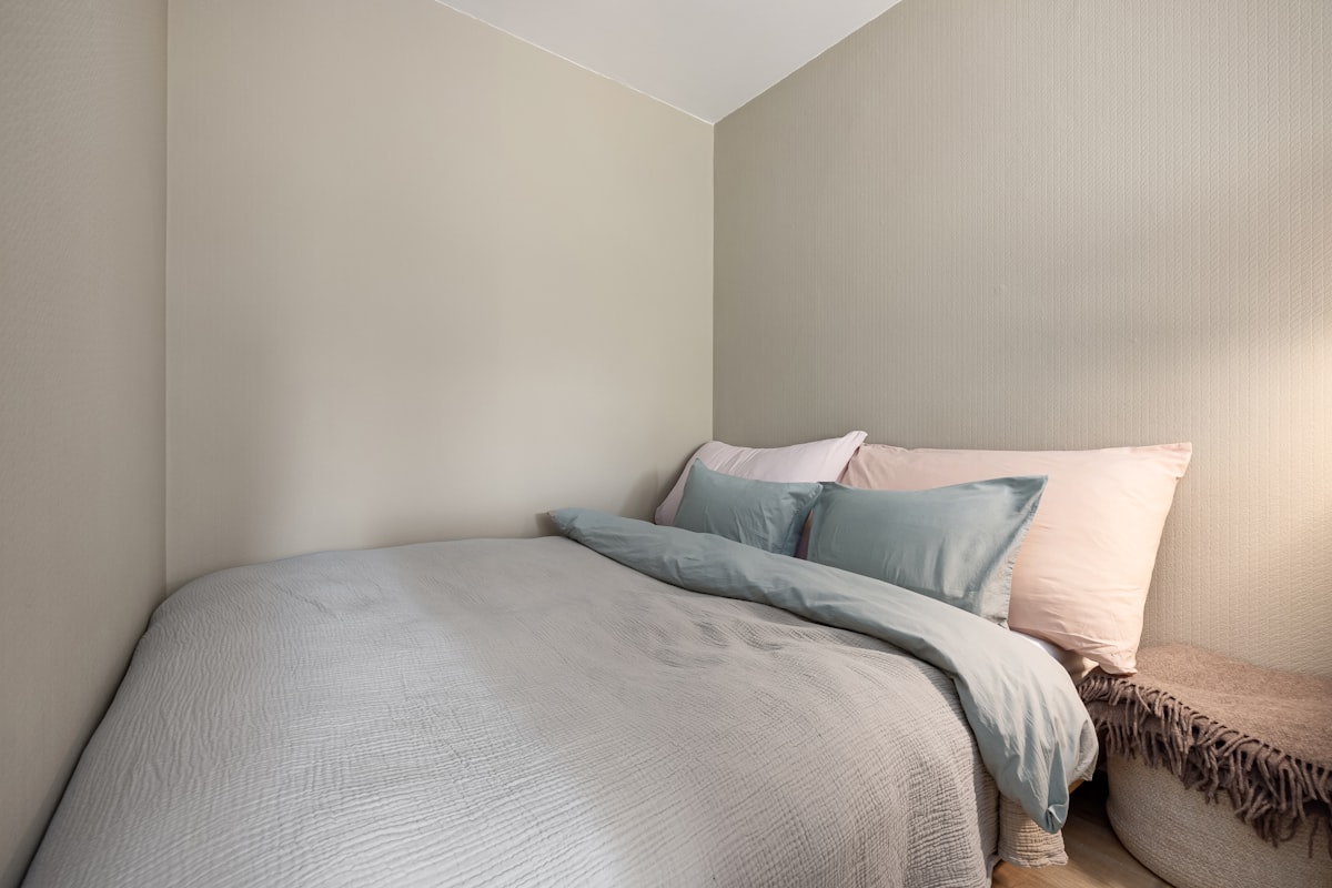 A bed sitting under a window next to a wooden floor related to Everything You Need to Know About Small Double Beds