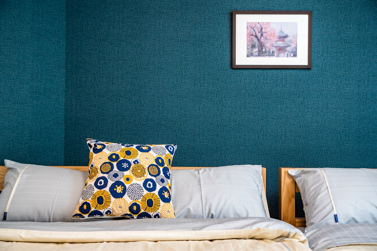 a bed with a pillow and a picture on the wall related to The Ultimate Comfort: Double Room with Two Double Beds