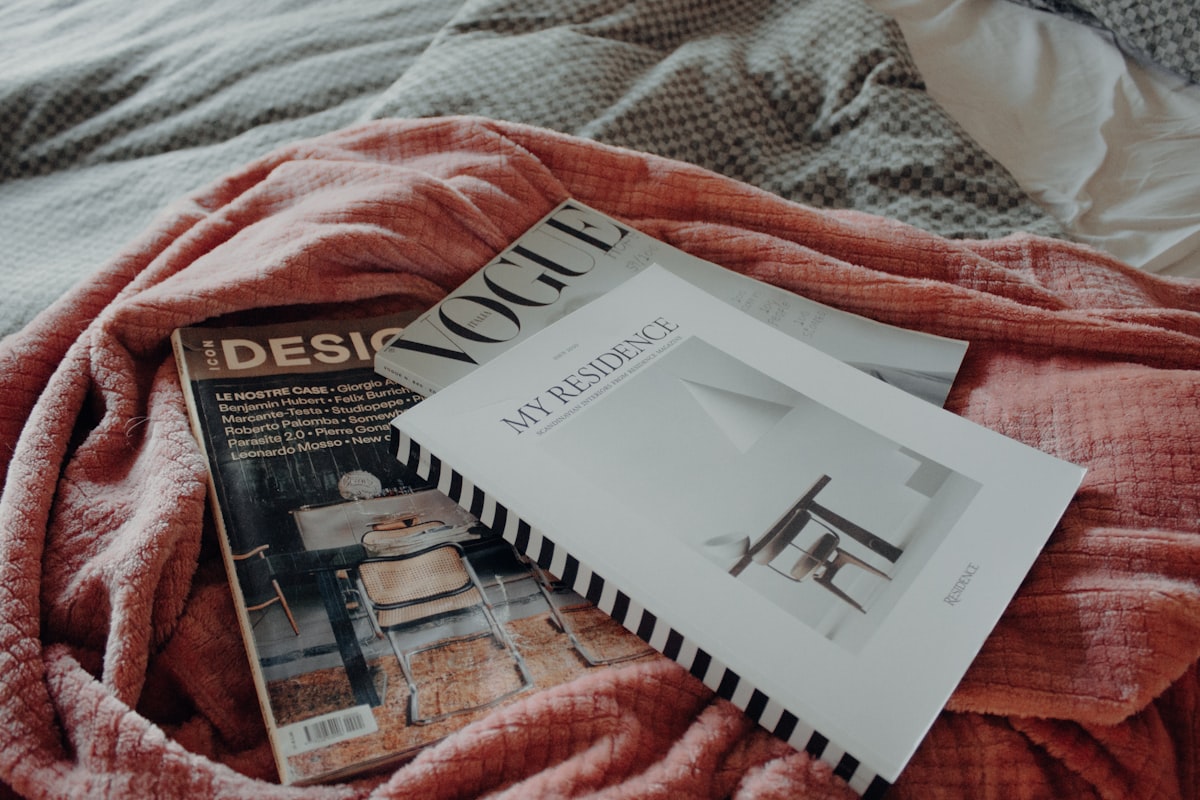 a bed with a red blanket and a book on top of it related to Transform Your Space with the Perfect Day Bed Bedding