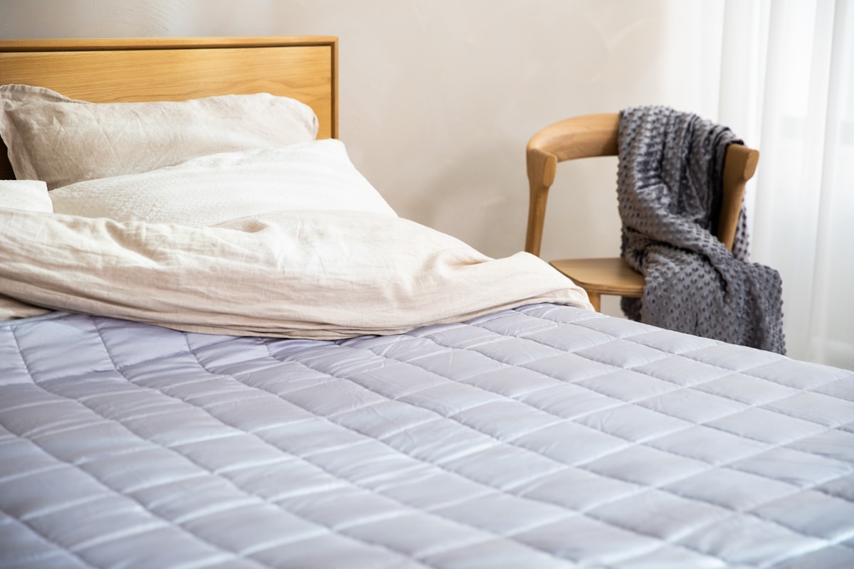 a bed with a white comforter and a wooden headboard related to Cozy Up with Cotton Quilts and Coverlets: The Ultimate Guide
