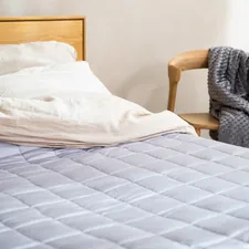 a bed with a white comforter and a wooden headboard related to Cozy Up with Cotton Quilts and Coverlets: The Ultimate Guide