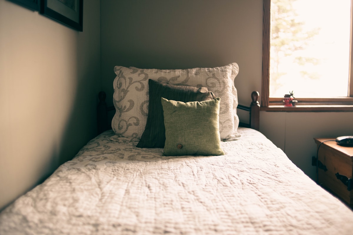 a bed with a white comforter and two pillows related to The Ultimate Guide to Single Bed Size: Measurements, Benefits, and Buying Tips