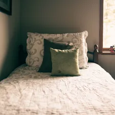 a bed with a white comforter and two pillows related to The Ultimate Guide to Single Bed Size: Measurements, Benefits, and Buying Tips