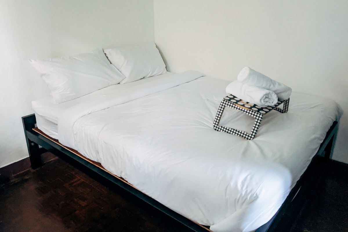 a bed with white sheets and pillows in a room related to Mastering the Art of Sleep: Everything You Need to Know About Full Size Beds