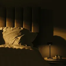 a bedroom with a bed and a night stand related to Exploring the Benefits of Light Headed Beds for Better Sleep