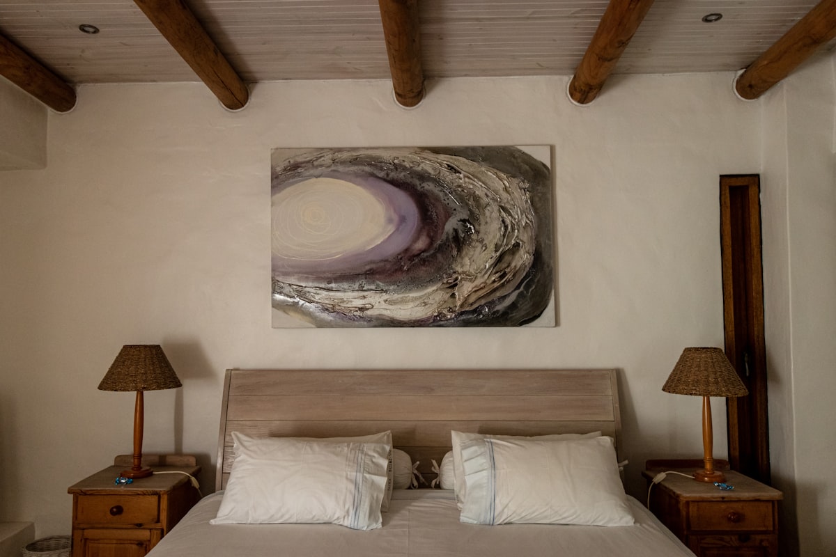 A bedroom with a bed and a painting on the wall related to Discover Tranquility at Casa de Sueños Bed and Breakfast