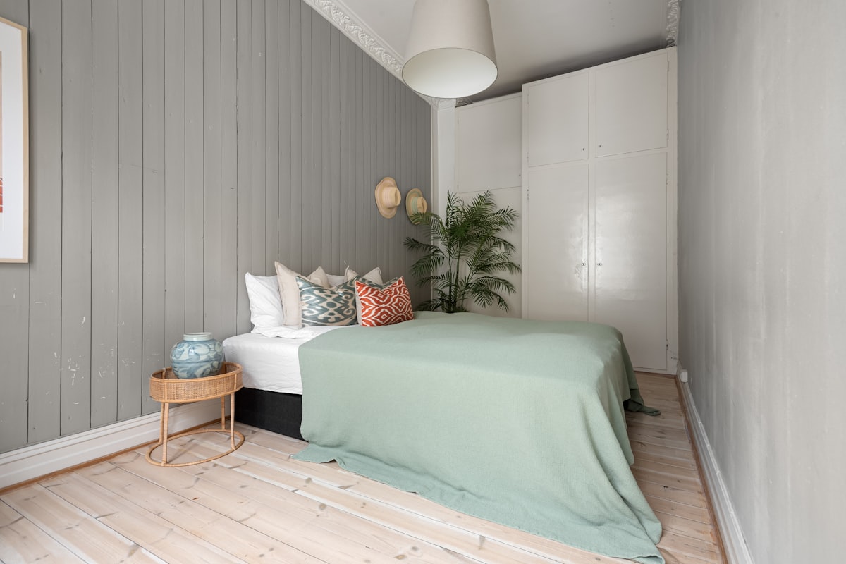 A bedroom with a bed and a painting on the wall related to Stylish Combinations for Your Bedroom