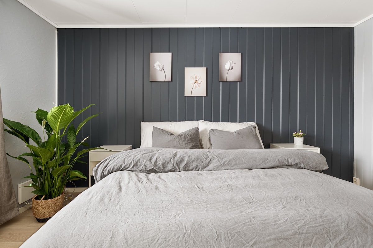 A bedroom with a bed and a plant in the corner related to Stylish Bedding Ideas for a Modern Bedroom