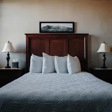 A bedroom with a bed and two lamps related to The Ultimate Guide to King Bed Sizes