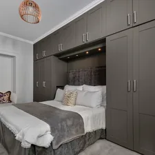 A bedroom with a bed, cabinets, and a chandelier related to Maximizing Space with a Twin Murphy Bed: A Game-Changing Solution