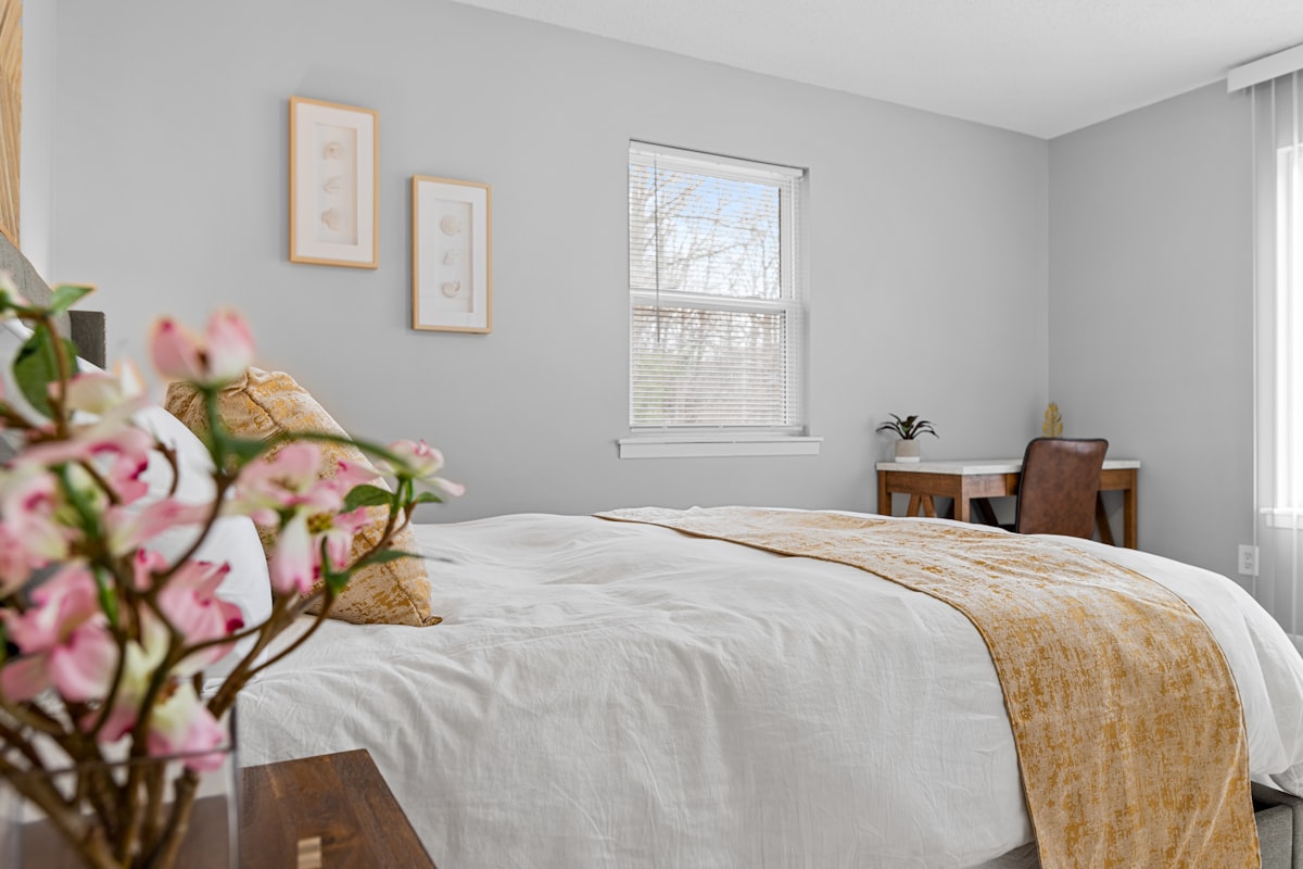 a bedroom with a bed, desk, and window related to Elevate Your Bedroom with a Queen Quilted Coverlet