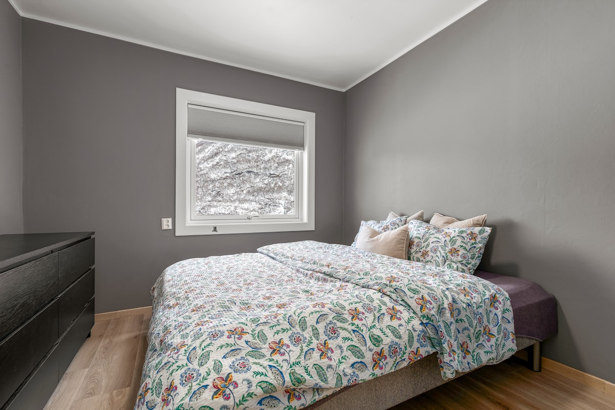 A bedroom with a bed, dresser and window related to Cozy Up with Frozen Twin Bedding: A Magical Slumber Experience