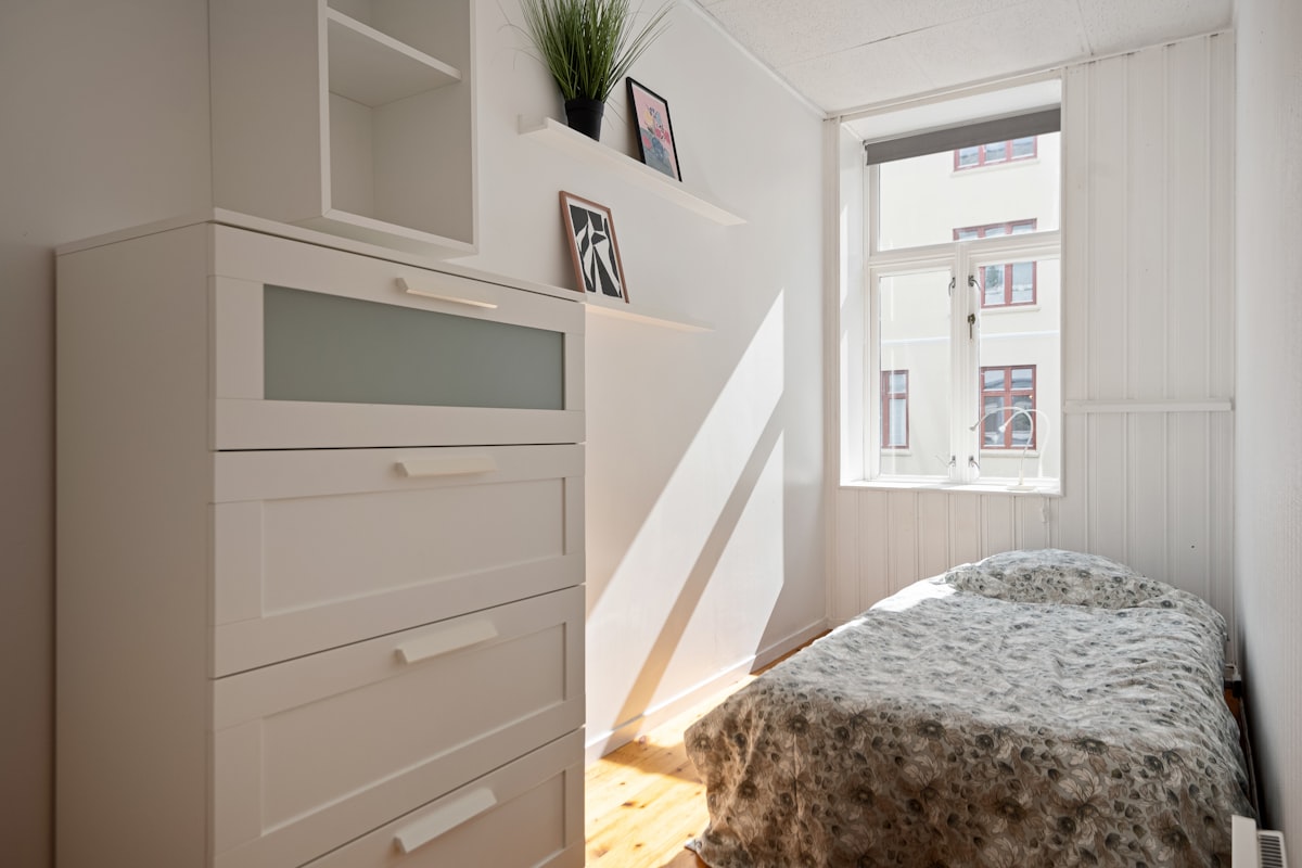 A bedroom with a bed, dresser, and window related to Maximizing Space with Twin Loft Bed with Storage Solutions