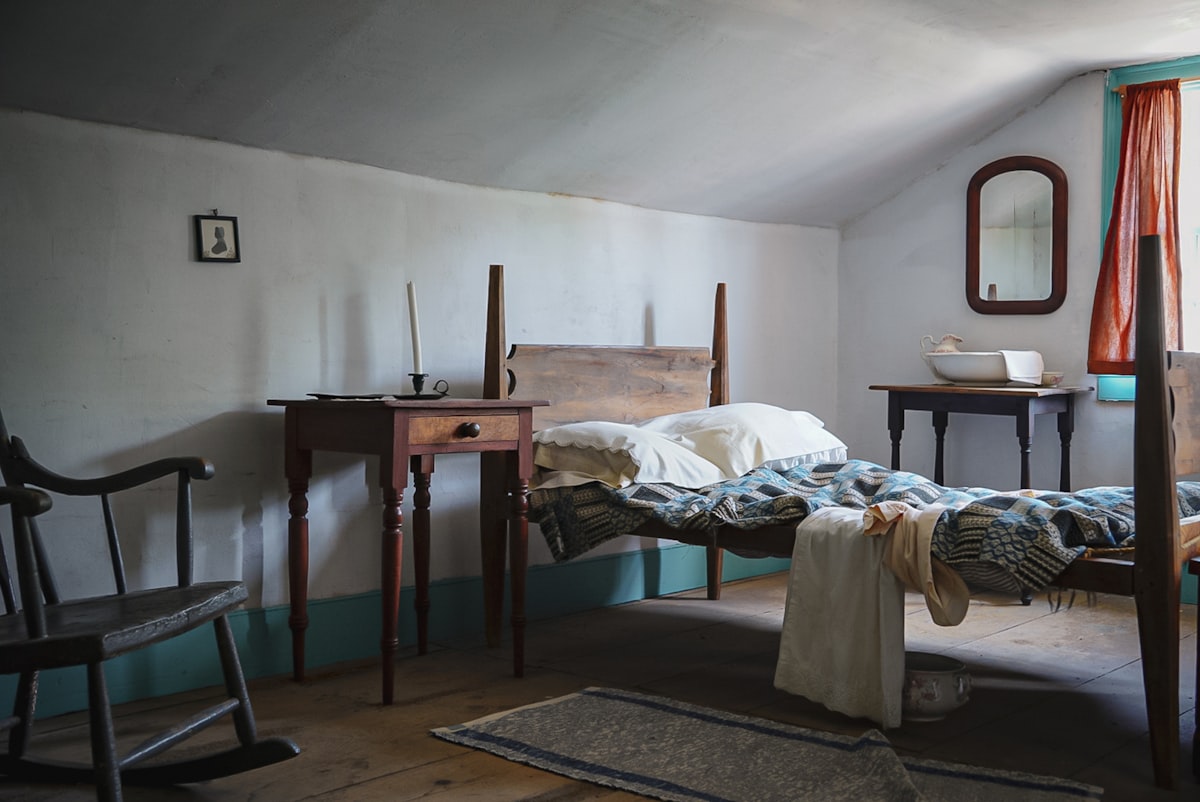 A bedroom with a bed, dresser, chair and mirror related to Rocking Your Way to Relaxation: The Benefits of Rocking Beds for Adults