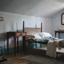 A bedroom with a bed, dresser, chair and mirror related to Rocking Your Way to Relaxation: The Benefits of Rocking Beds for Adults