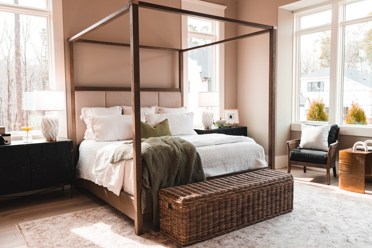 a bedroom with a four poster bed and a wicker trunk related to The Ultimate Guide to Canopy Bed Frames