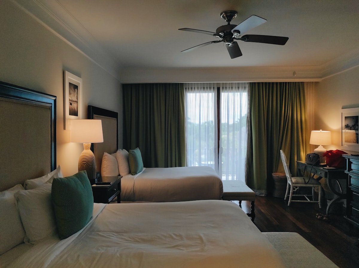 a bedroom with a large bed and a fan related to Discover the Best Rooms to Go King Beds for Ultimate Comfort