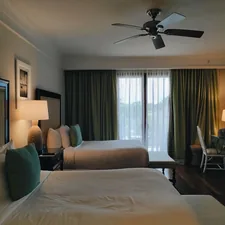 a bedroom with a large bed and a fan related to Discover the Best Rooms to Go King Beds for Ultimate Comfort
