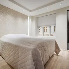 A bedroom with a large bed and a sliding glass door related to Bed Bath and Beyond Application