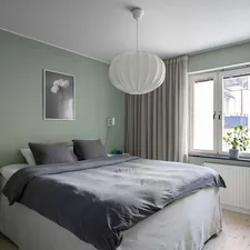 A bedroom with a large bed and a window related to Mint to Be: Refreshing Your Bedroom with Mint and Gray Bedding