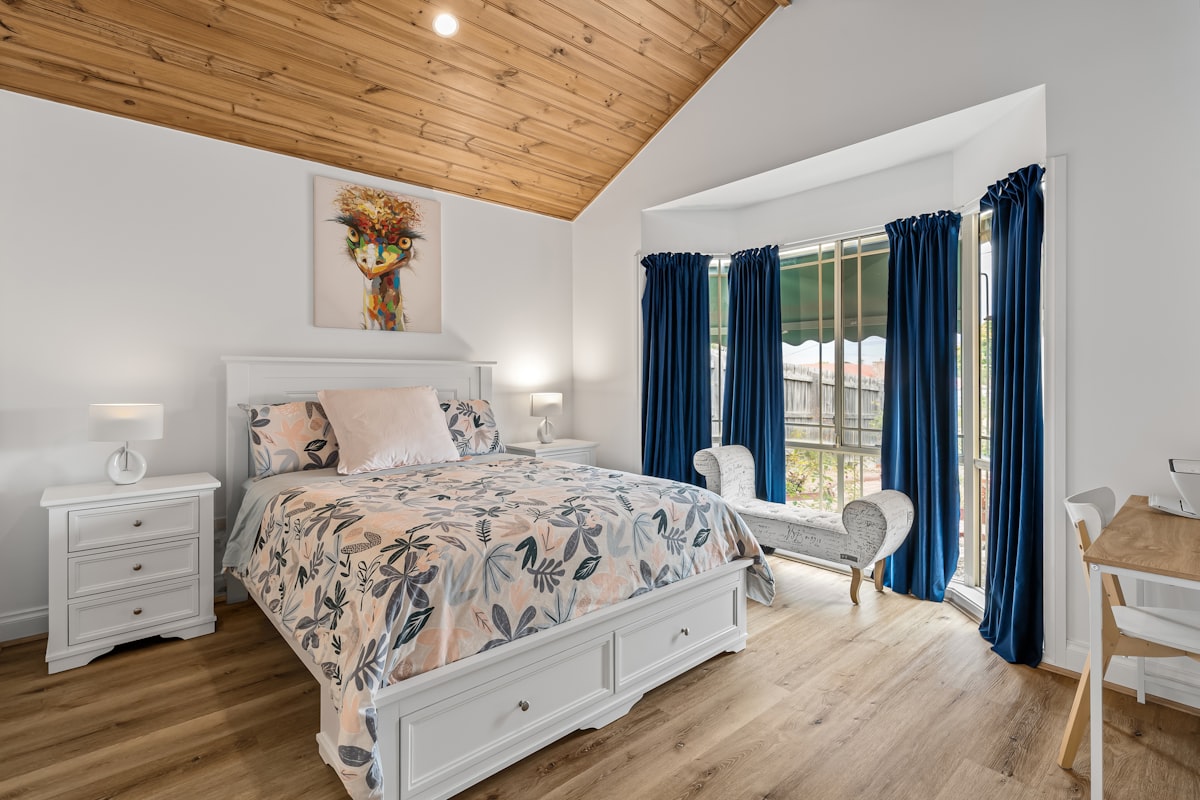 A bedroom with a large bed and a wooden ceiling related to Maximizing Space: A Comprehensive Guide to Queen Beds with Drawers