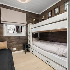 A bedroom with bunk beds and a couch related to Sleep Smart: A Guide to Finding the Best Cheap Bunk Beds
