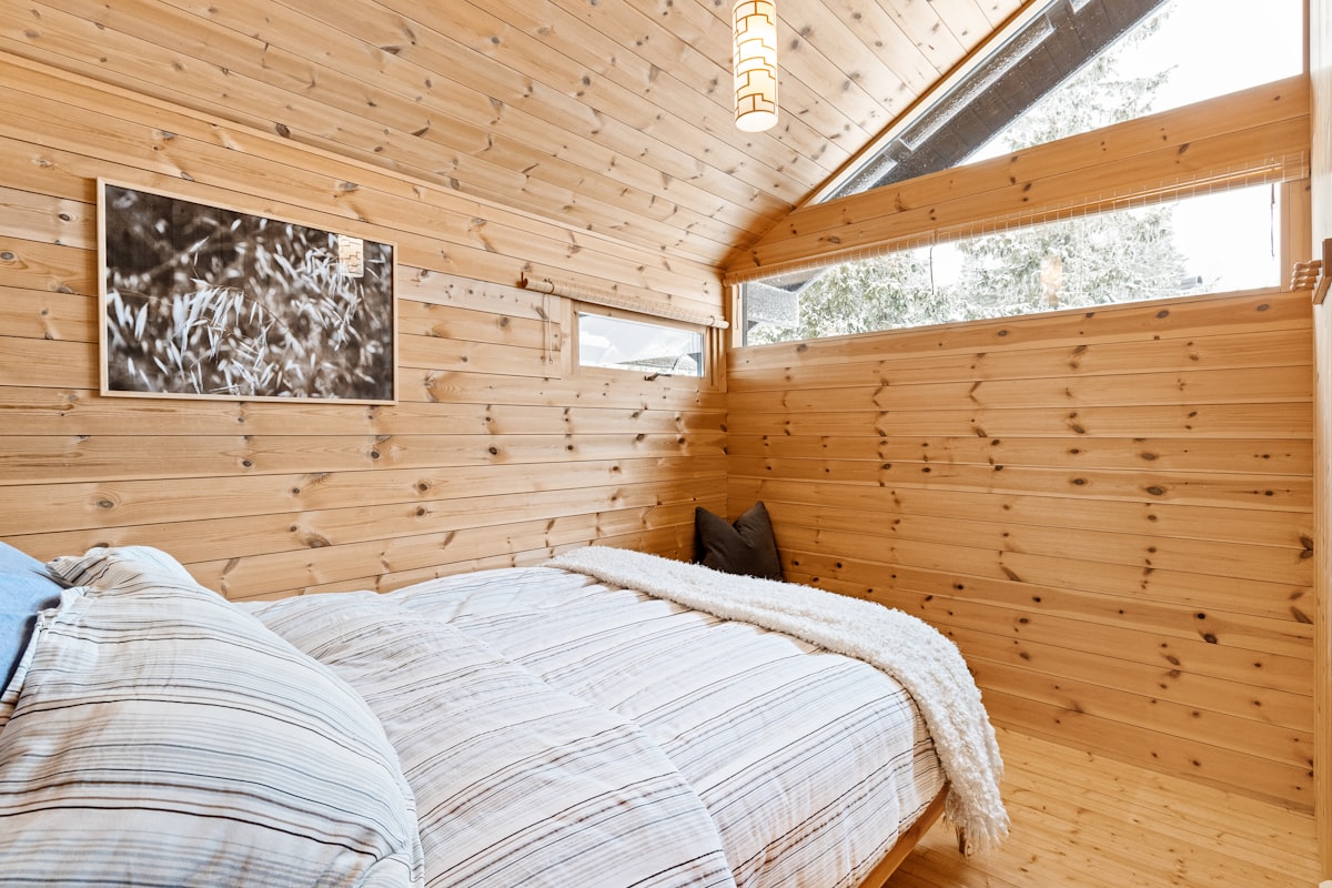 A bedroom with wood walls and a bed related to Treehouse Loft Bed Wonderland
