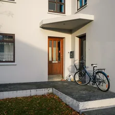 A bicycle parked outside a white house entrance. related to Elevate Your Home's First Impression: Front Door Entryway Ideas