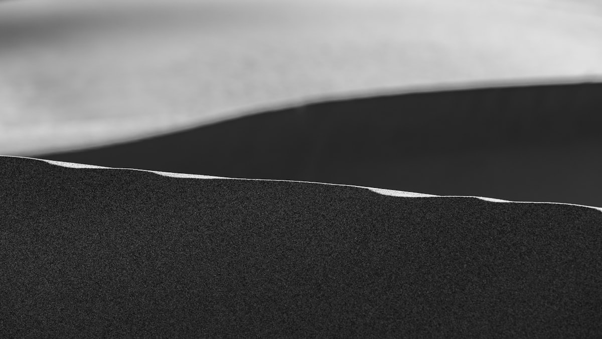 a black and white photo of a bed with white sheets related to The Allure of Black Upholstered Beds