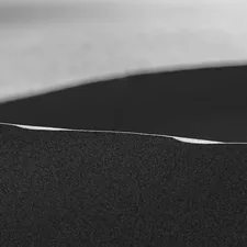 a black and white photo of a bed with white sheets related to The Allure of Black Upholstered Beds