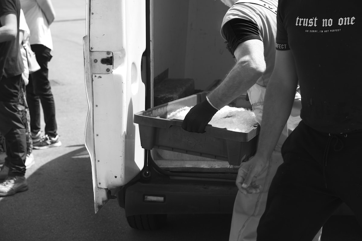 a black and white photo of a man loading something into a truck related to Top Picks for Luggage at Bed Bath & Beyond