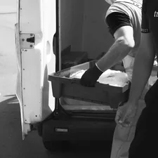 a black and white photo of a man loading something into a truck related to Top Picks for Luggage at Bed Bath & Beyond