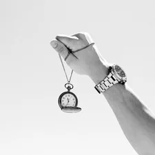 a black and white photo of a person holding a watch related to Exploring the Timeless Charm of Ethan Allen Sleigh Beds